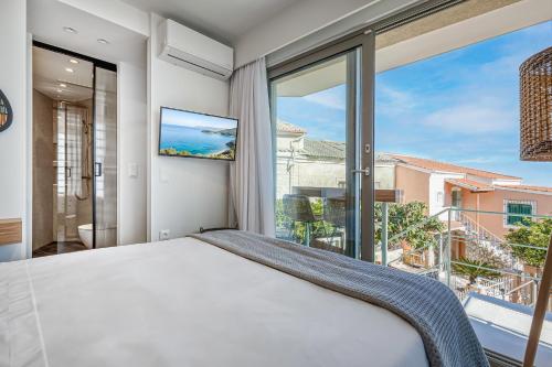 a bedroom with a bed and a large window at TINY HOUSE STUDIO AT COURTYARD COTTAGE CORFu in Lákones