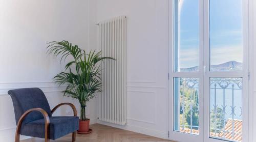 a room with a chair and a plant and a window at LEtoile du Lac in Blevio