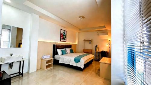 a hotel room with a bed and a sink at De BOUGENVILLE Tulap Beach Front in Watulanei