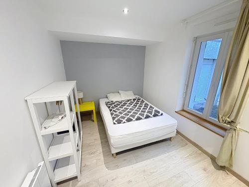 a small bedroom with a bed and a window at Le Petit Curie in Gien