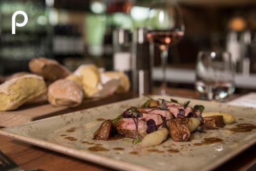a plate of food on a table with a glass of wine at Hotel Papendal in Arnhem