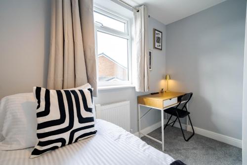 a bedroom with a bed with a desk and a window at Spacious 3 Bedroom House in Ashton-under-Lyne by Eason Stays with Free Parking and Courtyard View in Stalybridge