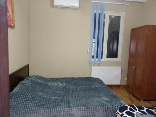 a small bedroom with a bed and a window at Jesis Batumi in Batumi
