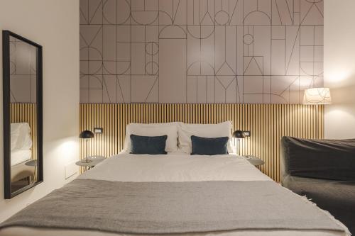a bedroom with a large bed with two pillows at Rooms Boutique Carducci in Trieste