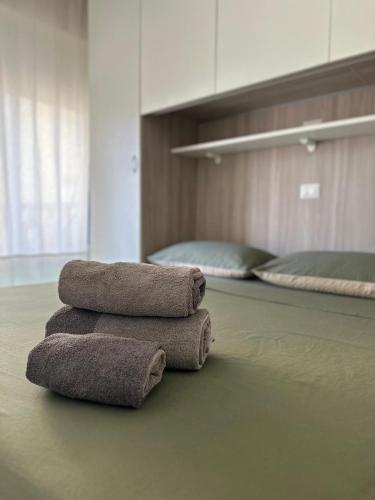 three towels sitting on the floor in a room with two beds at Bibione Beach Home in Bibione
