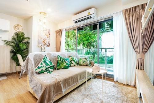 a living room with a couch and a large window at Phyll Condominium Luxury 301 2bedroom, Phuket in Ban Rangeng