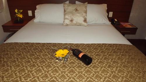 a bed with a bottle of champagne and flowers on it at Hotel Retiro 84 in Bogotá