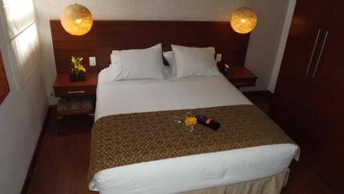 a hotel room with a large bed with two lamps at Hotel Retiro 84 in Bogotá