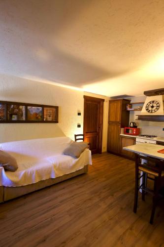 a bedroom with a bed and a desk with a clock at Maison Rita e Cello in La Salle