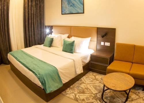 a hotel room with a bed and a chair at Caritas Inn Igbobi in Lagos