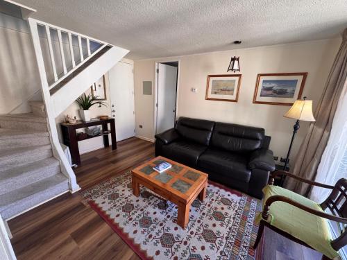 a living room with a black couch and a coffee table at Decher Apartment - Puerto Varas in Puerto Varas