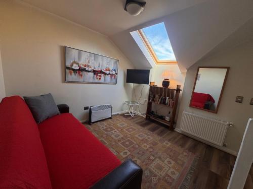 a living room with a red couch and a mirror at Decher Apartment - Puerto Varas in Puerto Varas