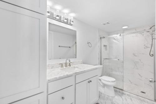 a white bathroom with a toilet and a shower at Sun 'n Surf in Inlet Beach