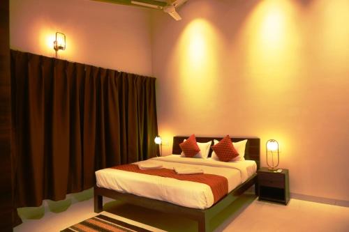 a bedroom with a large bed with red pillows at The Infinity Pench Resort in Khawāsa