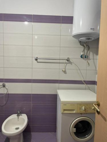 a bathroom with a sink and a washing machine at Endi Apartments 2 in Tirana