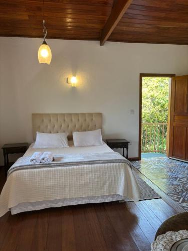 a bedroom with a large bed with two towels on it at Chalé Aconchego da Paz - Chalé 2 in Lavras Novas
