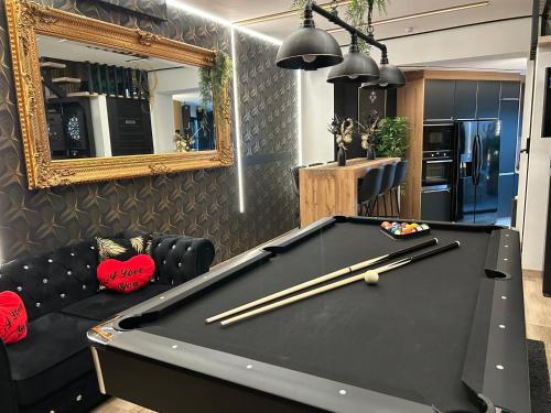 a pool table in a living room with a mirror at Chambre de charme, sauna, jacuzzi,billard VIP, clim in Verviers