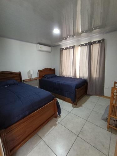 a bedroom with two beds and a window at Tucan Apartment in Agua Azul