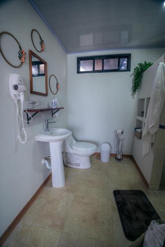 a bathroom with a white toilet and a sink at Tucan Apartment in Agua Azul