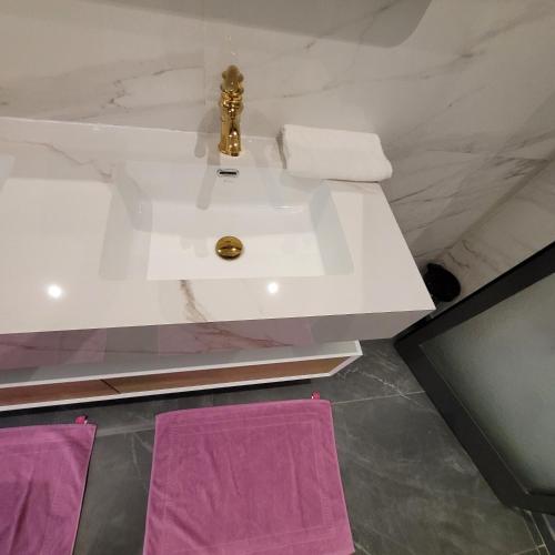 a bathroom with a sink and two purple towels at Villa burj in Ngaparou