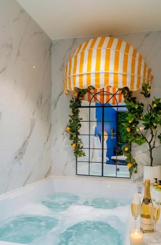 a jacuzzi tub with a window in a room at Ciao Bella Wellness Suite - Luxury Jacuzzi, Massage Table & AC in Central Nice in Nice