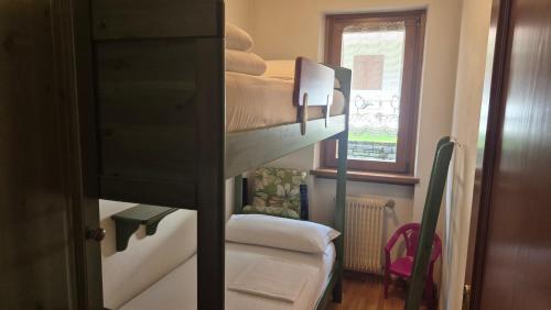 a room with two bunk beds and a window at Saroio B in Auronzo di Cadore
