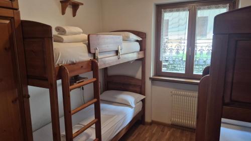 a room with four bunk beds and a window at Saroio B in Auronzo di Cadore