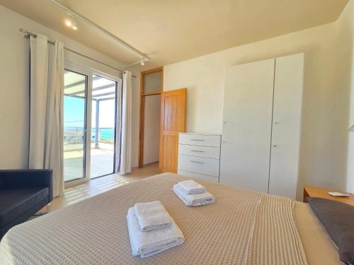 a bedroom with a bed with two towels on it at Villas By George in Afiartis