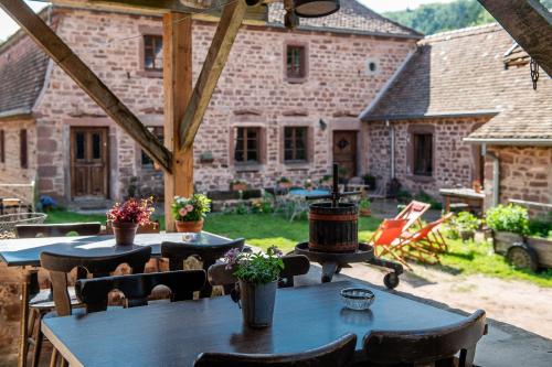 a patio with tables and chairs in front of a building at Maison d'hôtes complète La Paulusmühle in Soucht