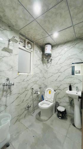 a bathroom with a toilet and a sink at Cozy Cove in Jaipur