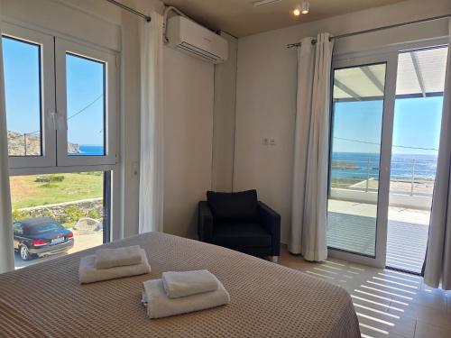 a bedroom with a bed and a chair and a window at Villas By George in Afiartis