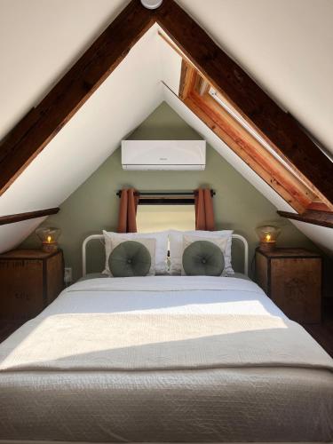 a bedroom with a white bed in the attic at Spoor 2 met Wellness in Nieuwe Vaart