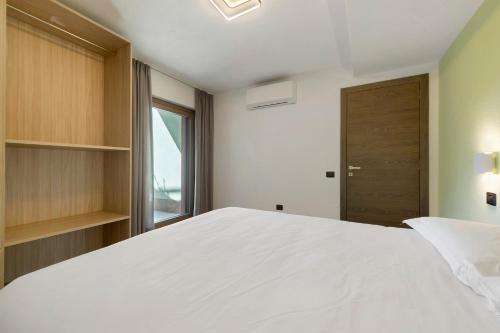 a bedroom with a large white bed and a window at Appartamenti Suly 2 - Cir0083 in Saint Vincent