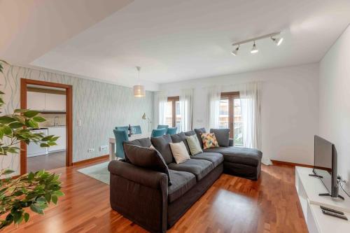 a living room with a couch and a television at Modern 2 bedroom apt 20 min from city center in Amadora