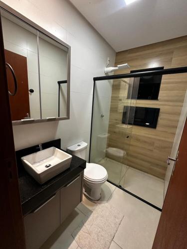 a bathroom with a toilet and a sink and a shower at Sobrado amplo com churrasqueira in Rio Verde