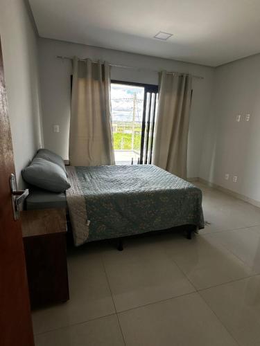a bedroom with a bed and a window at Sobrado amplo com churrasqueira in Rio Verde