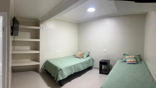 a bedroom with two beds and a book shelf at Hostal sol del norte in Paipote