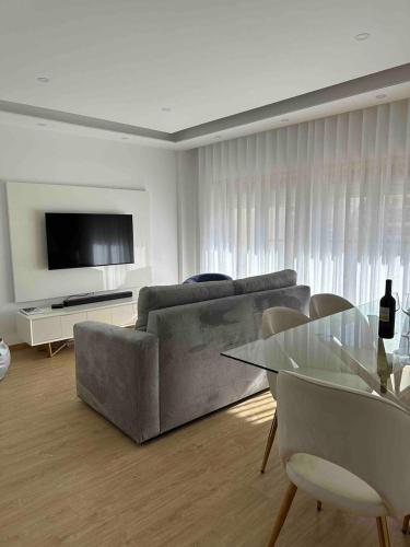 a living room with a couch and a table at Glam 2 bedroom In Massamá in Massamá