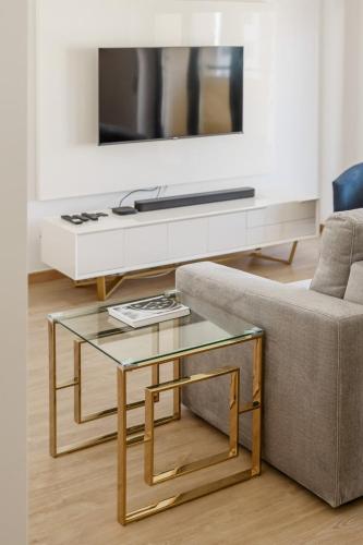 a living room with a couch and a glass coffee table at Glam 2 bedroom In Massamá in Massamá