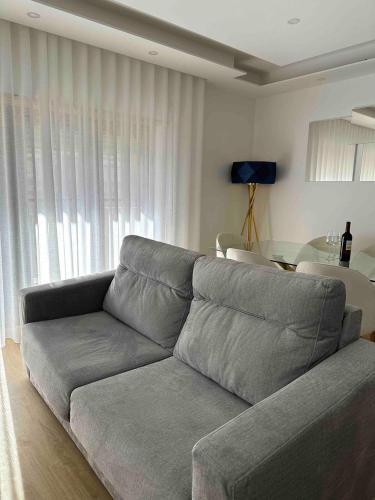 a living room with a gray couch and a table at Glam 2 bedroom In Massamá in Massamá
