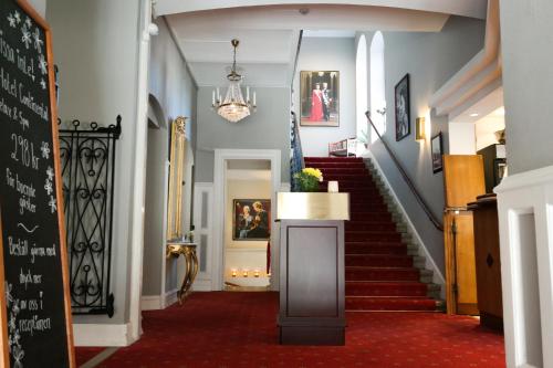 a hallway with a staircase with a table in it at Hotel Continental Relax & Spa, BW Signature Collection in Halmstad