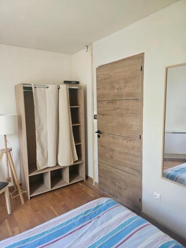 a bedroom with a bed and a sliding door at Nuits Dijon Chambre in Dijon