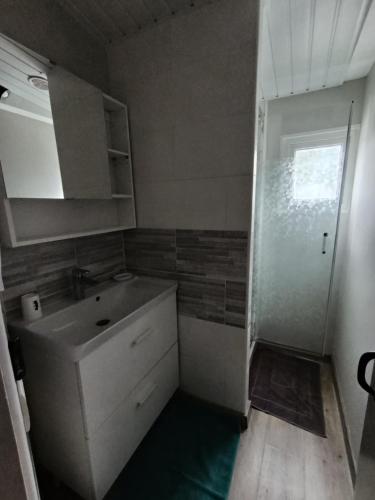 a small bathroom with a sink and a shower at Mobilhome rénove climatisé - 10min plage - Mimizan in Mimizan