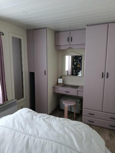 a bedroom with a bed and a desk and a mirror at Mobilhome rénove climatisé - 10min plage - Mimizan in Mimizan
