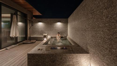 a woman standing in a bath tub in a room at Mungyeong Sadamjae Stay in Mungyeong