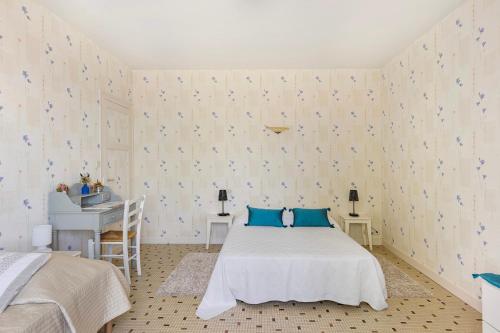 a bedroom with a bed with blue pillows and a desk at Gîte La Salamandre in Mosnes