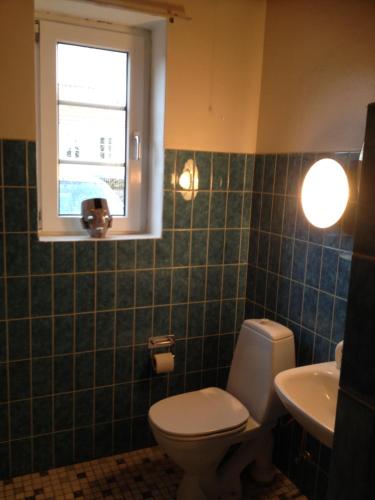 baño con aseo y lavabo y ventana en Sommerlyst en Løkken