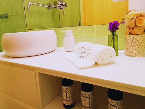 a bathroom counter with a sink and towels on it at Refúgio Brisa Mar in Vila do Conde