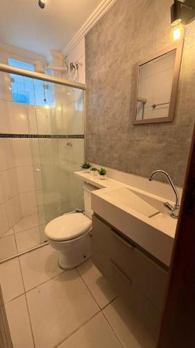 a bathroom with a toilet and a sink and a shower at Apartamento Ilhéus próximo à praia in Ilhéus