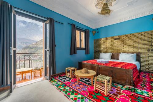 a bedroom with a bed and a large window at Le Reflet D'Imlil in Imlil